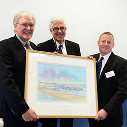 Robert Smith, Harbour Master at the Port of Wells, being presented a painting of the Outer Harbour in Wells by Einar Strømsvâg and the artist John Hurst.
